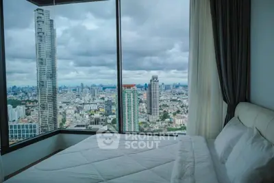 Luxurious bedroom with panoramic city view from high-rise apartment window.