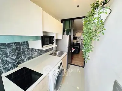 Modern kitchen with sleek appliances and stylish backsplash in a compact layout.