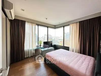 Spacious bedroom with city view, large windows, and modern furnishings in a high-rise apartment.