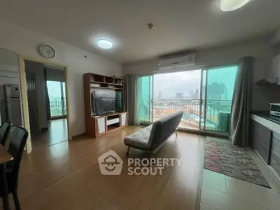 Spacious living room with modern decor and city view from large windows in a high-rise apartment.