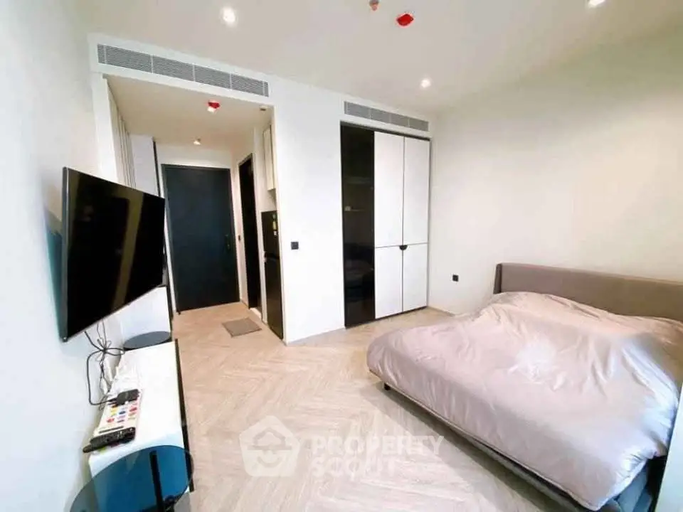 Modern bedroom with sleek design and mounted TV in a stylish apartment.