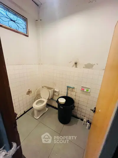 Simple bathroom with basic amenities and tiled walls