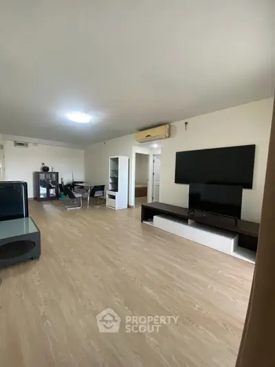 Spacious modern living room with sleek flooring and large TV setup