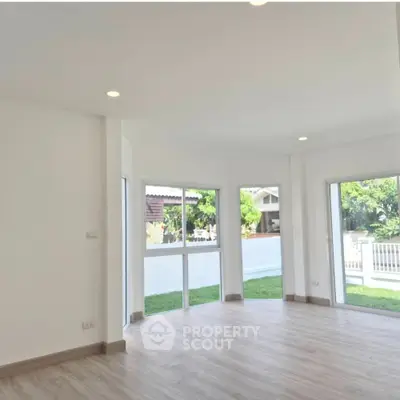 Bright and spacious living room with large windows and garden view