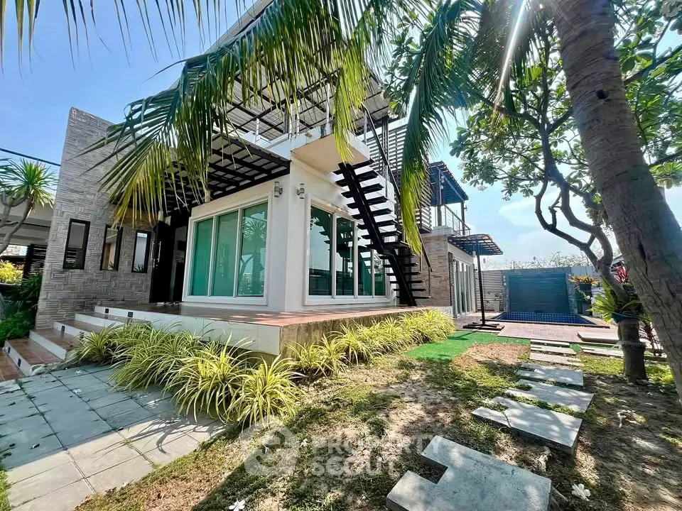 Stunning modern home with lush garden and outdoor staircase, perfect for luxury living.