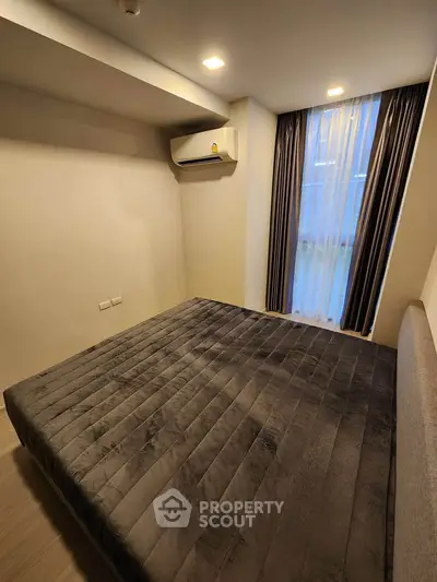 Cozy bedroom with modern air conditioning and elegant curtains, perfect for restful nights.