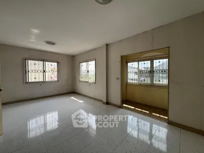 Spacious empty room with tiled flooring and large windows for natural light