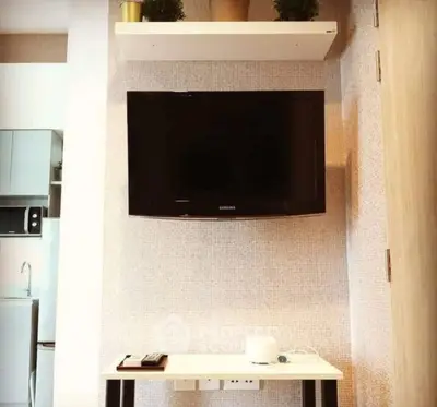 Modern living room with wall-mounted TV and sleek furniture in a stylish apartment.