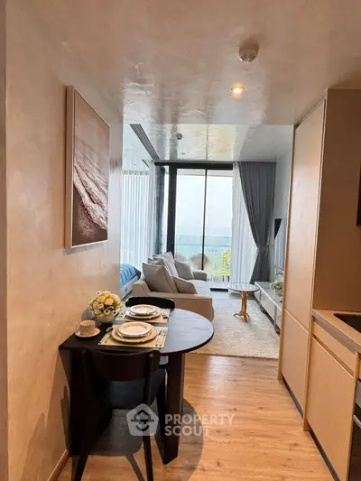 Chic modern living room with ocean view, cozy seating, and elegant dining setup.