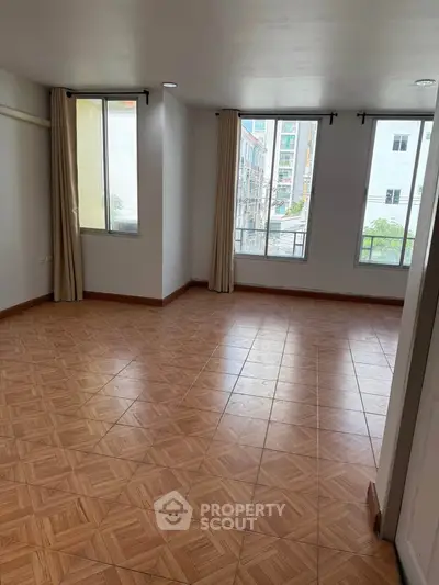 Spacious empty room with large windows and tiled flooring, perfect for customization.