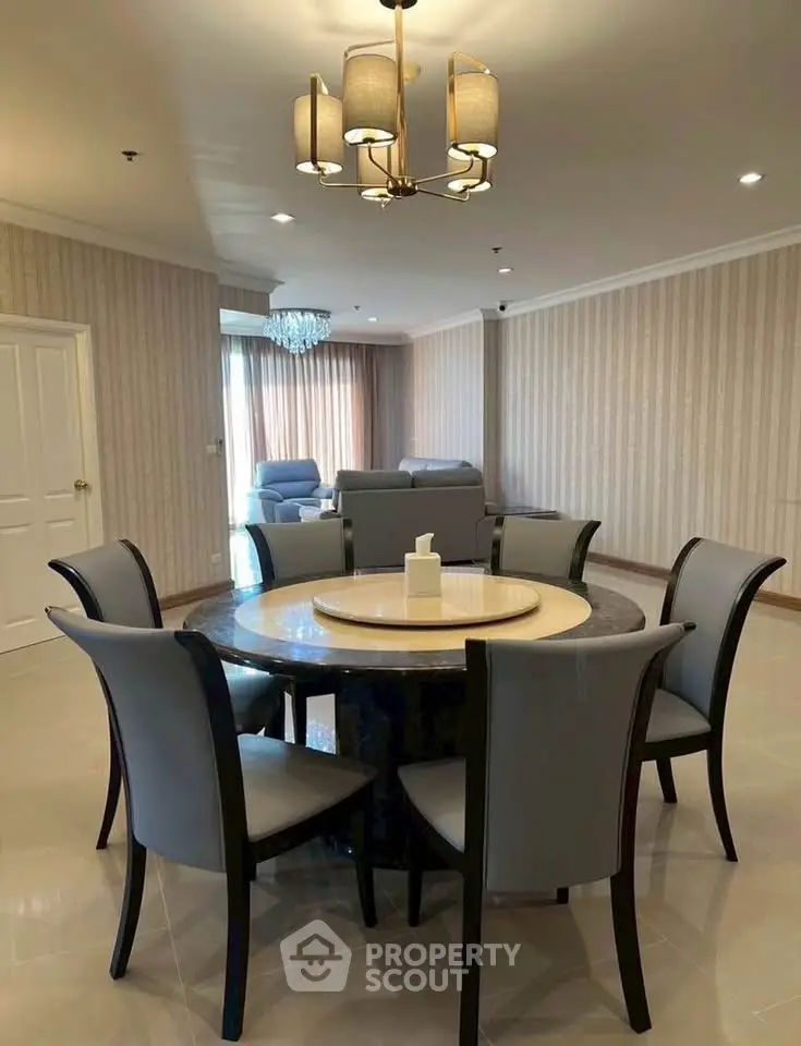Spacious dining area with elegant round table and modern chandelier in a stylish living room.