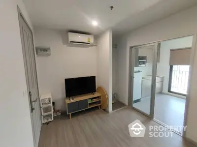 Modern living room with air conditioning and sliding glass doors leading to a bright balcony area.