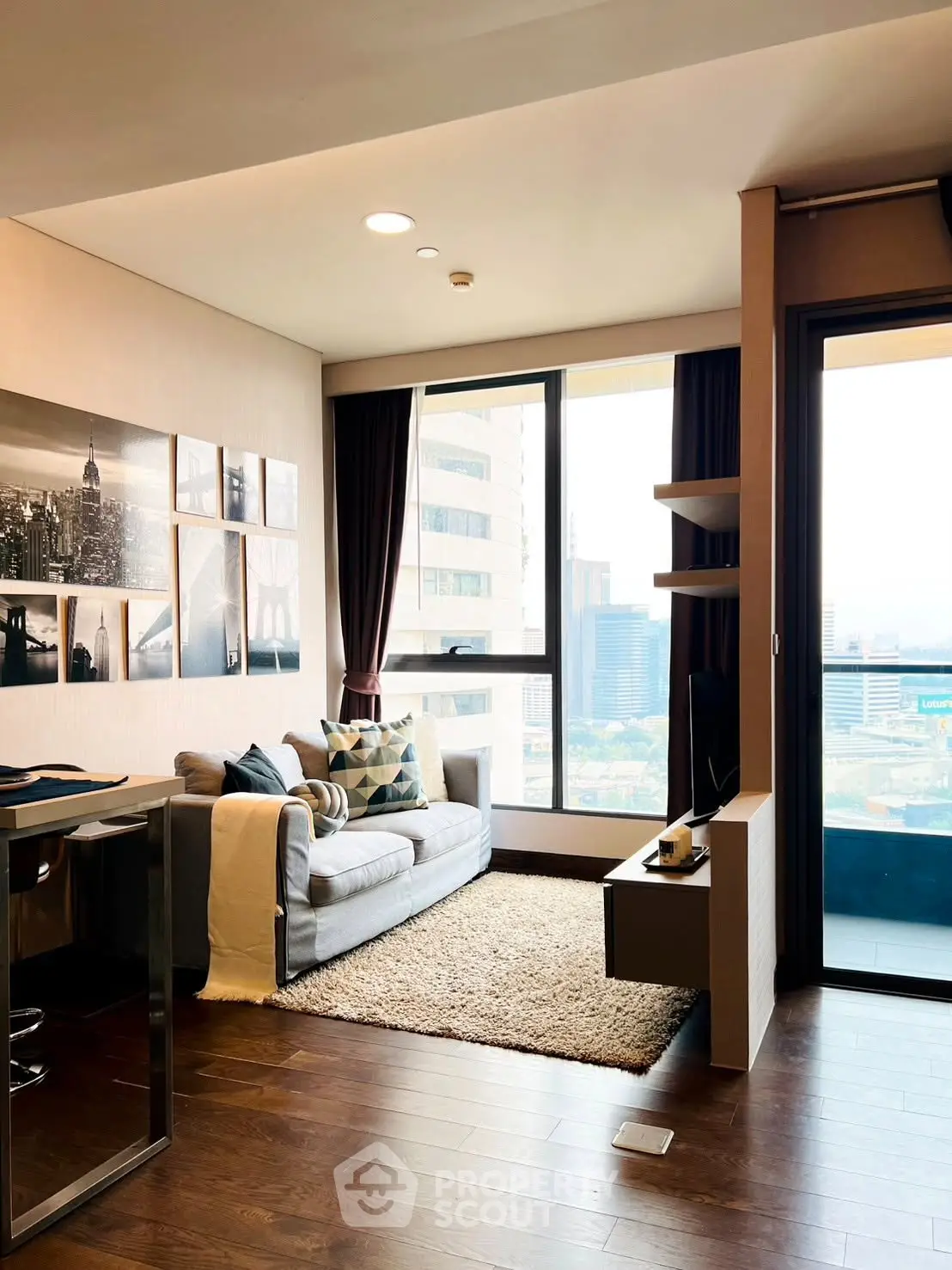 Modern living room with city view, stylish decor, and cozy seating area.