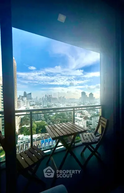 Stunning cityscape view from a modern balcony with stylish outdoor furniture.