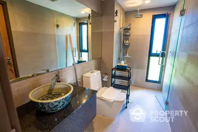 Luxurious modern bathroom with unique basin and glass shower enclosure