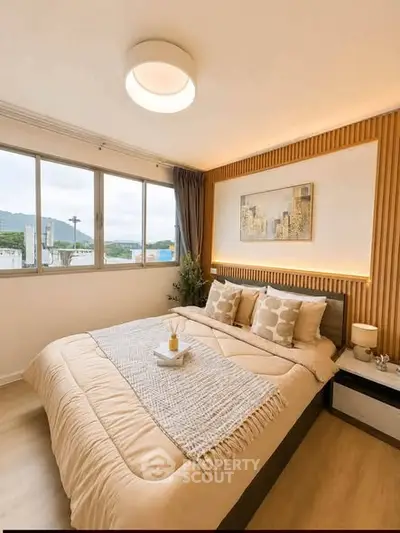 Cozy bedroom with modern decor and large window offering scenic views.