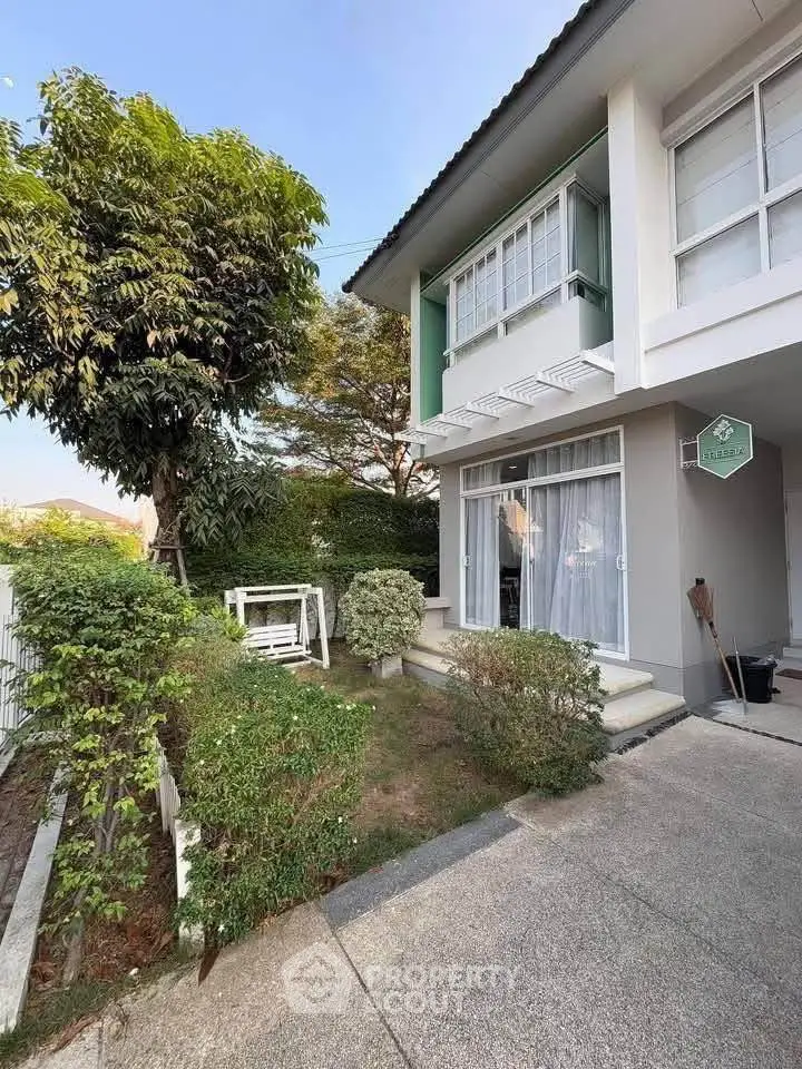 Charming two-story home with lush garden and inviting entrance