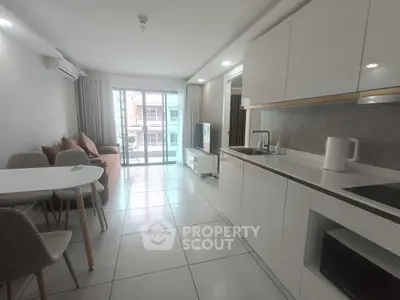 Modern open-plan living room and kitchen with sleek design and natural light.