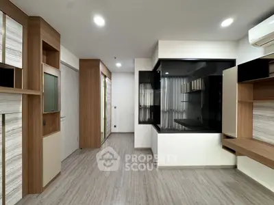 Modern minimalist living room with sleek wood finishes and built-in storage solutions.