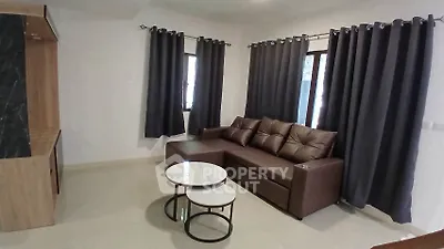 Modern living room with sleek brown sofa and stylish curtains, perfect for cozy relaxation.