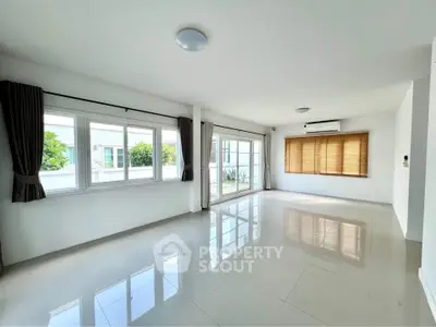 Spacious empty living room with large windows and glossy tiled floor