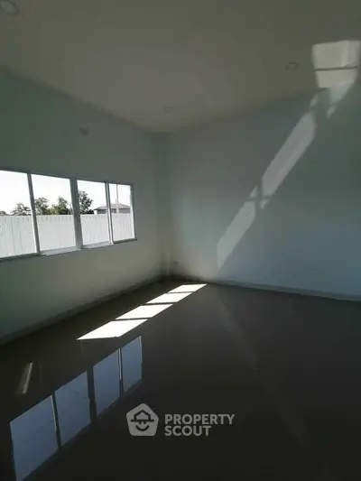 Spacious empty room with large windows and glossy tiled floor, perfect for customization.
