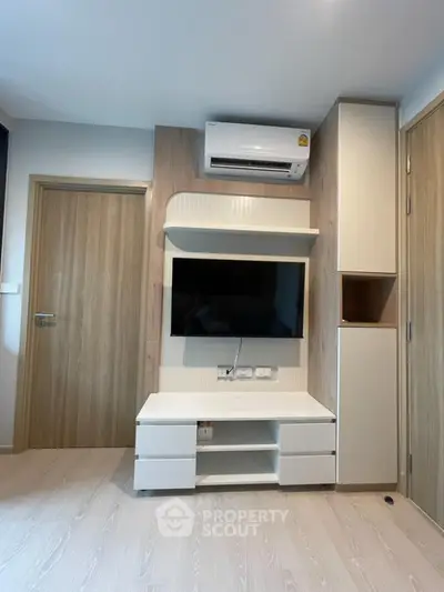 Modern living room with sleek TV setup and air conditioning unit
