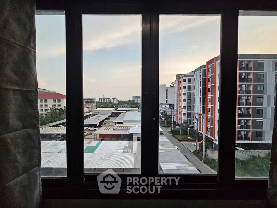 Stunning urban view from a modern apartment window showcasing vibrant cityscape and contemporary architecture.