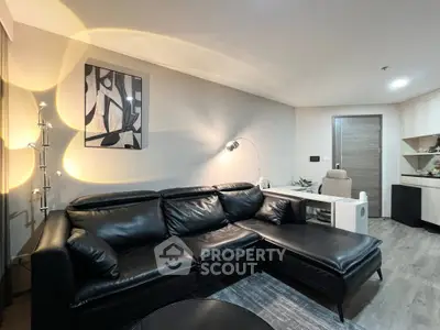 Modern living room with black leather sofa and stylish decor