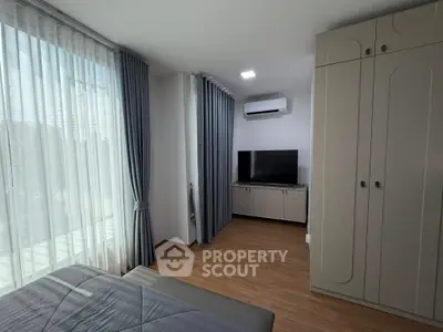 Modern bedroom with large window, stylish curtains, and sleek furniture