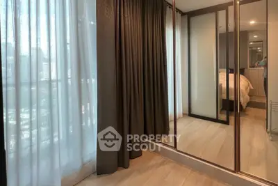 Spacious bedroom with mirrored closet and large window offering natural light.