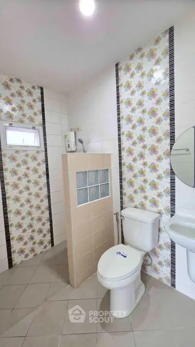 Charming bathroom with colorful tile accents and modern fixtures, perfect for a cozy home.