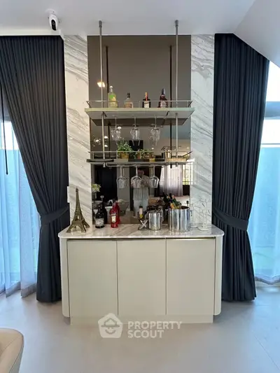 Elegant home bar setup with marble backsplash and stylish shelving in a modern living space.