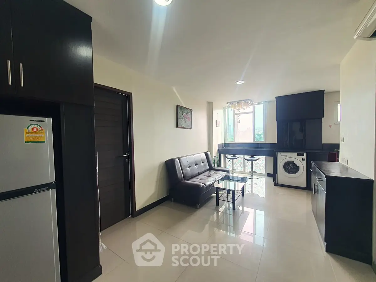 Modern living room with sleek furniture and in-unit washing machine, perfect for urban living.