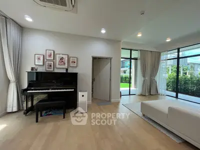 Spacious living room with piano and garden view, perfect for family gatherings.