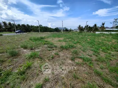 Spacious vacant land with lush greenery and clear blue sky, ideal for development opportunities.