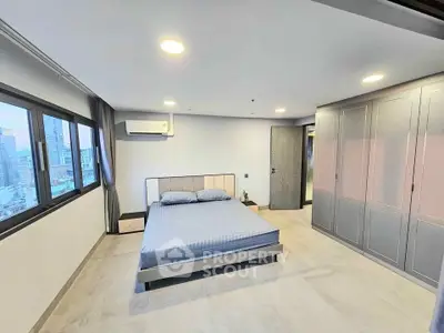 Spacious modern bedroom with city view and sleek built-in wardrobe