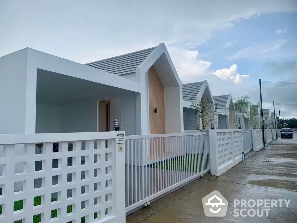 Modern minimalist white houses with sleek design and spacious front yards in a serene neighborhood.