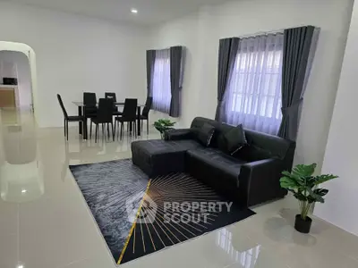 Modern living room with sleek black furniture and elegant dining area