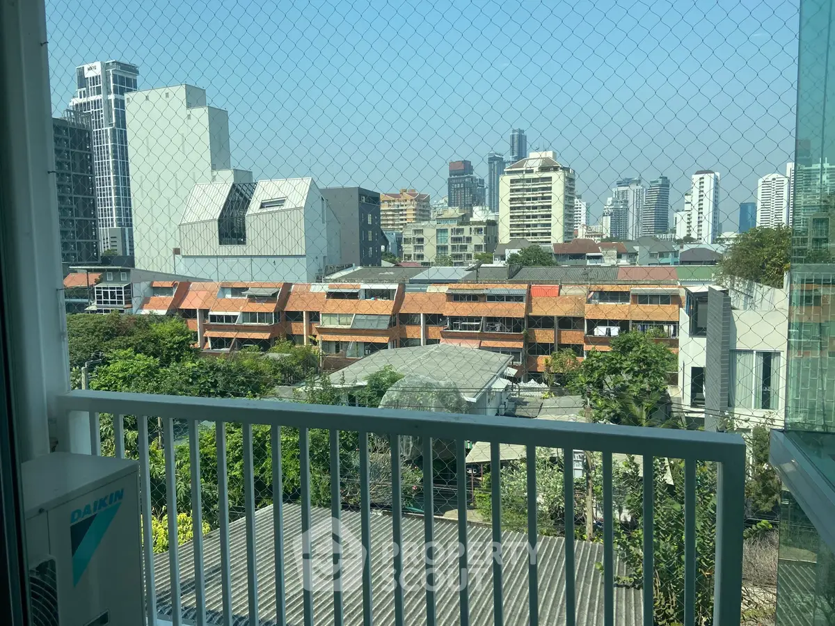 Stunning cityscape view from a high-rise balcony with lush greenery and modern architecture.