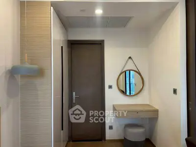 Modern entryway with stylish mirror and compact desk in a cozy apartment.