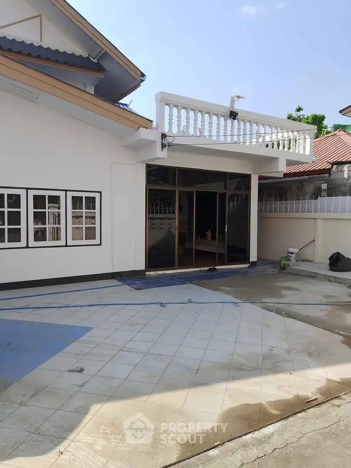 Charming single-story home with spacious tiled patio and modern glass doors, perfect for outdoor gatherings.