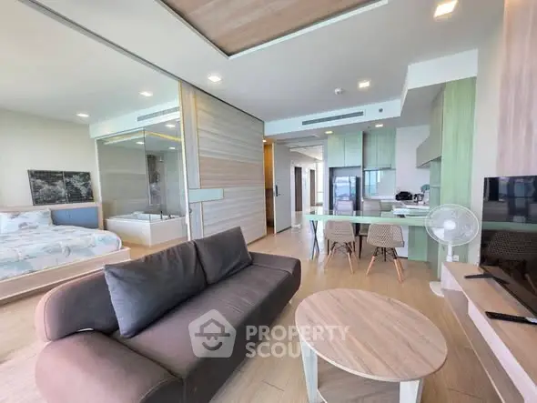 Modern open-plan living room with stylish furniture and integrated kitchen in a contemporary apartment.