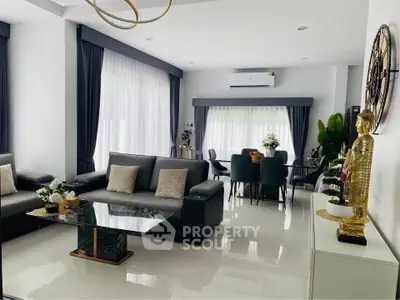 Luxurious modern living room with elegant decor and dining area, featuring sleek furniture and abundant natural light.