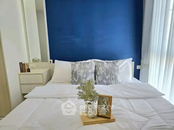 Modern bedroom with stylish blue accent wall and cozy bedding