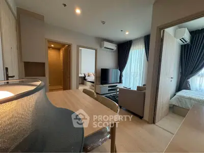 Modern apartment interior with open living area and two bedrooms, featuring stylish decor and natural light.