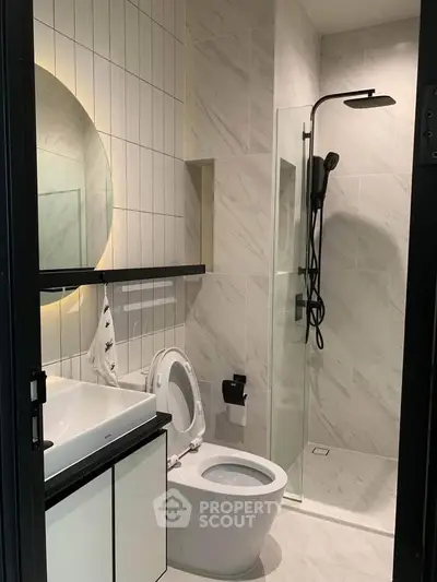Modern bathroom with sleek shower and stylish vanity in contemporary apartment.