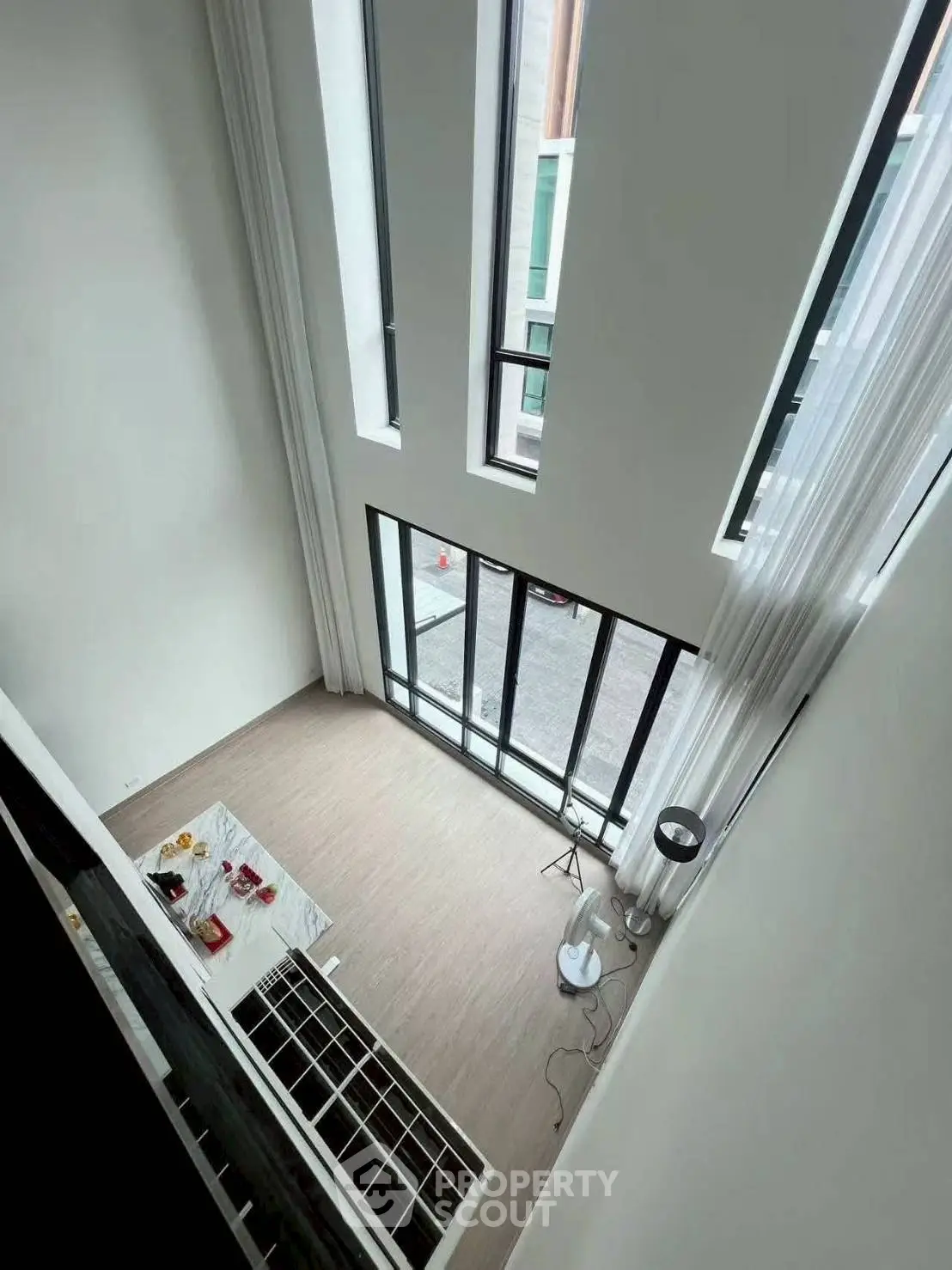 Stunning high-ceiling living room with large windows and modern decor