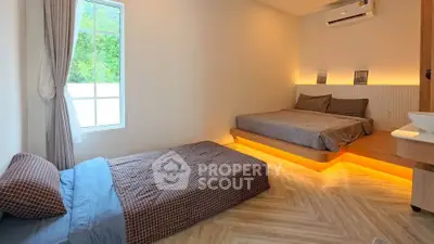 Modern bedroom with platform bed and ambient lighting, featuring a cozy single bed and large window.