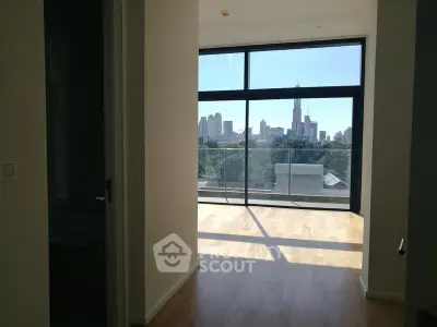 Spacious apartment with floor-to-ceiling windows offering stunning city skyline views.